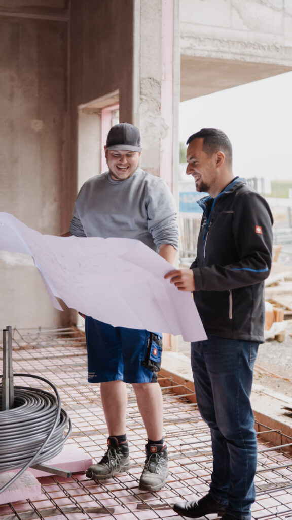 Zwei Installateure von Installateurhof Buchinger besprechen den Bauplan auf der Baustelle