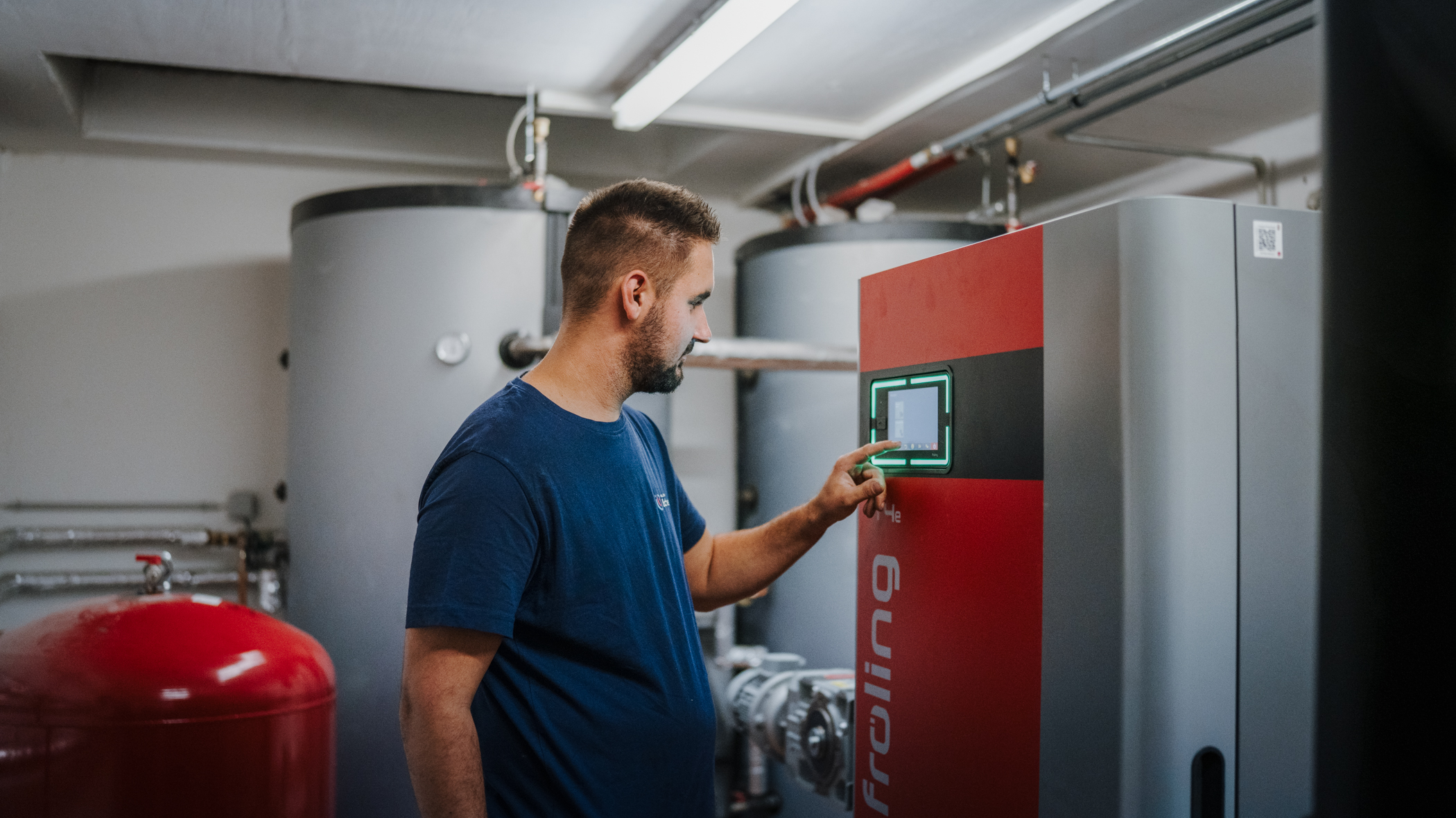 Techniker bedient die Steuerung eines Heizkessels im Heizraum